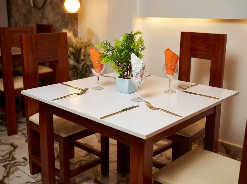 Table dressée du restaurant Julie Events : couverts dorés, verres et serviettes orange